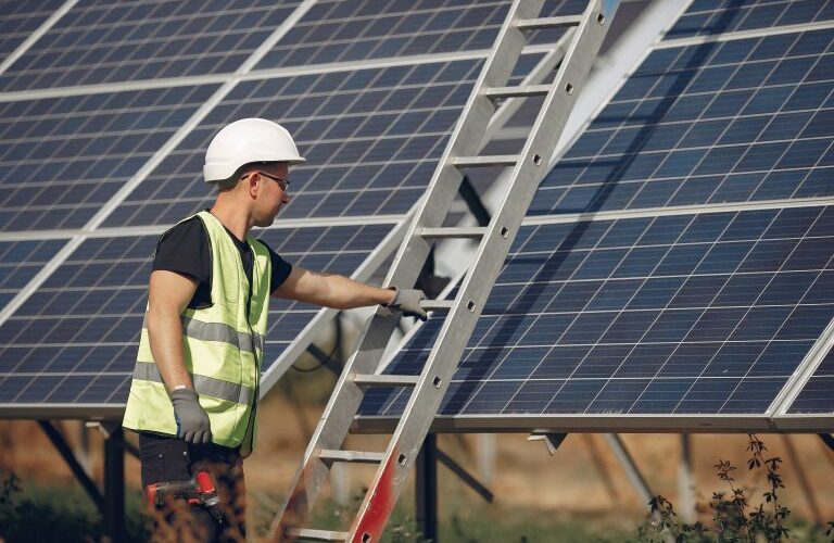 man-with-white-helmet-near-solar-panel-768x512